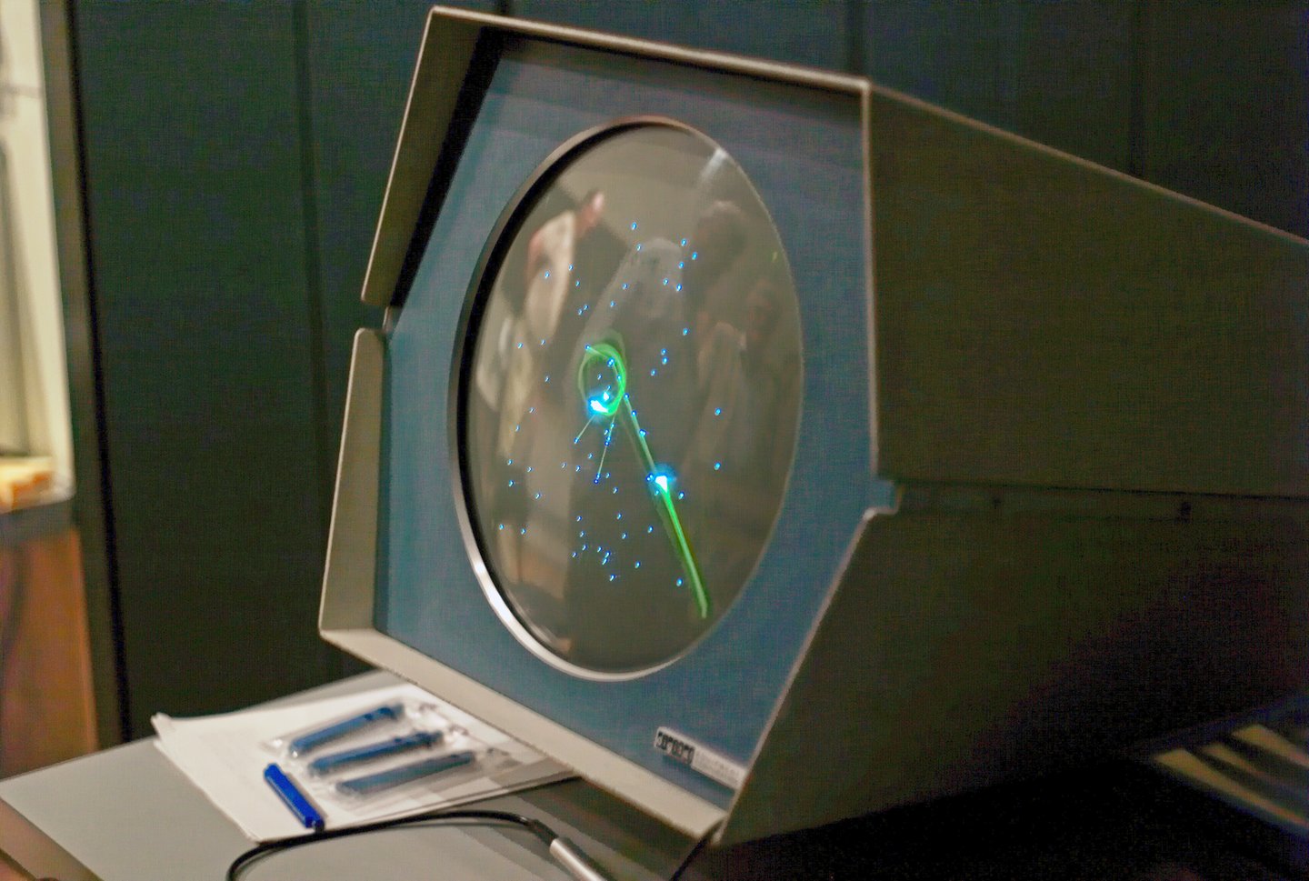 Spacewar! на круглом экране PDP-1: два небольших корабля среди светящихся звёзд